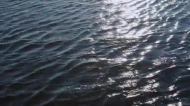 Denizin ya da okyanusun yüzeyinde güneş ışınları yansıyor..