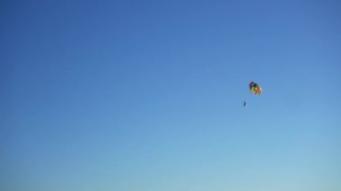 Paraşütçü mavi gökyüzüne doğru yükseliyor. Ekstrem sporlar. Tehlikeli eğlence sırasında adrenalin üretmek.