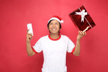 Kırmızı arka planda akıllı telefon taşıyan son sınıf öğrencisi hediyesi.