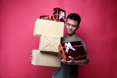  Asyalı adam kırmızı arka planda hediye veriyor. Yogyakarta Endonezya. 14 Aralık 2019