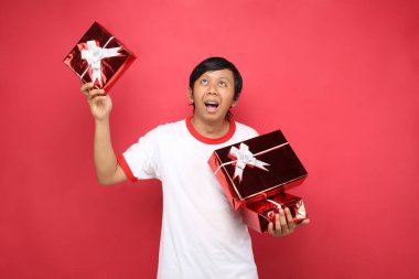 Şimdiki kutucuğu veren adam kırmızı arkaplanda izole edilmiş boş alana bakarken şaşırdı