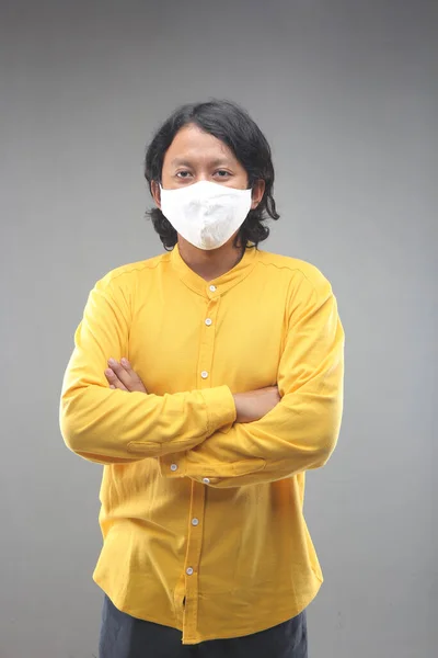 新しい普通のアジア人の男幸せな使用顔マスク用Covid 19で黄色のシャツでグレーの背景に隔離 — ストック写真