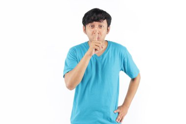 Endonezyalı genç adam sessiz ses için mavi tişörtlü jest yapıyor.