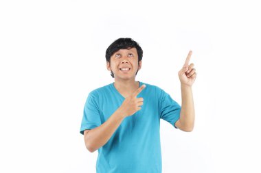 Asyalı erkek portresi boşluğu mavi tişörtle işaret ediyor.