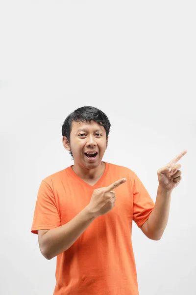 Asiático Hombre Apuntando Espacio Blanco Sonriendo Usando Naranja Camiseta —  Fotos de Stock