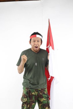 Endonezyalı kahraman el hareketleriyle gülümsüyor ve bayrak sallıyor.