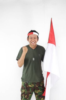 Endonezyalı kahraman el hareketleriyle gülümsüyor ve bayrak sallıyor.