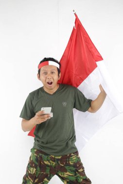 Bağımsızlık Günü Endonezyalı adam akıllı telefon kullanıyor ve elinde kırmızı beyaz bayrak tutuyor..