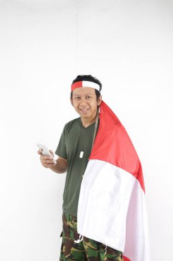 Mutlu Endonezyalılar akıllı telefon kullanır ve kırmızı beyaz bayrak tutar..