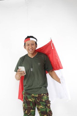 Mutlu Endonezyalılar akıllı telefon kullanır ve kırmızı beyaz bayrak tutar..