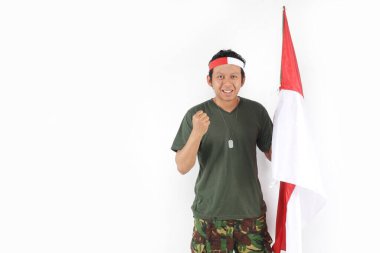 Endonezyalı kahraman el hareketleriyle gülümsüyor ve bayrak sallıyor.