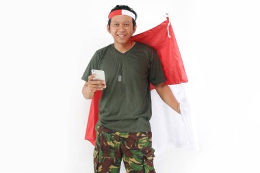 Endonezyalı usta akıllı telefon kullanıyor ve elinde kırmızı beyaz bayrak tutuyor..