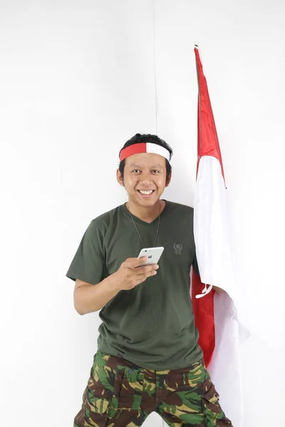 Nasionalis Indonesia Pria Menggunakan Smartphone Dan Memegang Bendera Putih Merah — Stok Foto