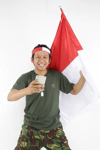 Prajurit Indonesia Menggunakan Smartphone Dan Memegang Bendera Merah Putih — Stok Foto