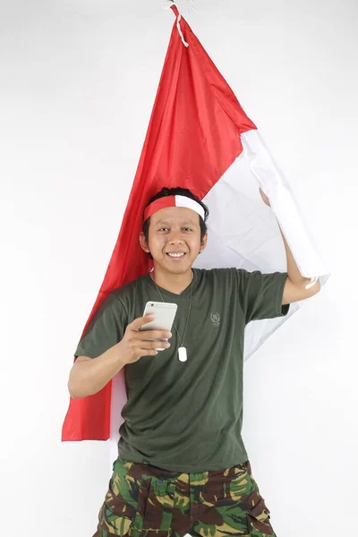 Armee Indonesien Mann Mit Smartphone Und Hält Fahne Rot Weiß — Stockfoto
