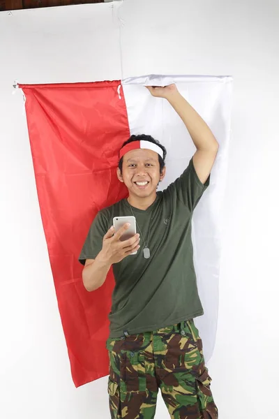 Indonesische Soldaat Man Met Behulp Van Smartphone Met Vlag Rood — Stockfoto