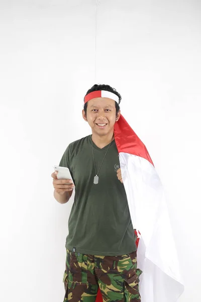 Indonesien Soldat Mann Lächelt Mit Smartphone Und Hält Fahne — Stockfoto