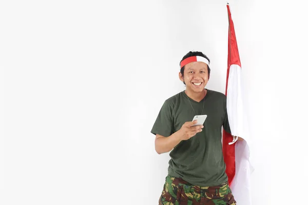 Prajurit Indonesia Tersenyum Menggunakan Smartphone Dan Memegang Bendera — Stok Foto