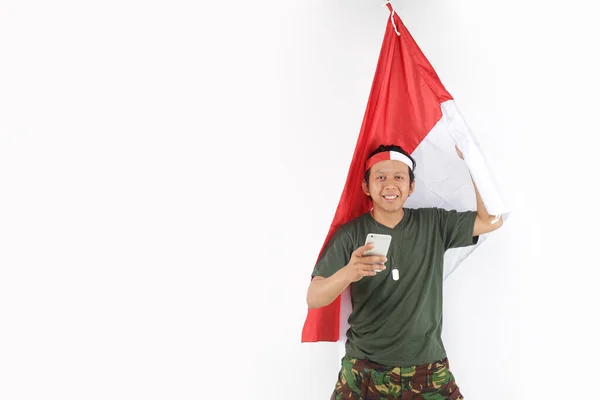 Indonesia Veterano Hombre Usando Teléfono Inteligente Celebración Bandera Roja Blanca —  Fotos de Stock