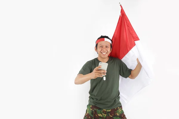 Indonesisk Hjälte Man Med Smartphone Och Hålla Flaggan Röd Vit — Stockfoto