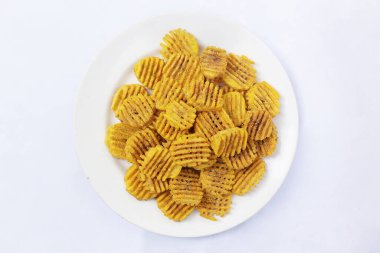 Tabaktaki muz cipsleri izole. Kızarmış muz cipsi