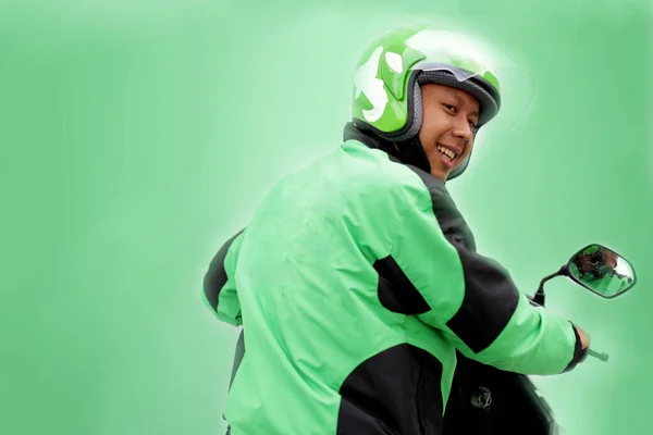 Motorsikletli adam üniformalı Gojek taksiyi devreye soktu. Yogyakarta Endonezya. 30 Mart 2020
