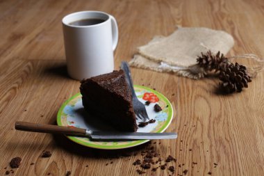 Browni yiyen kadın ve ahşap masa arkasında kahve yiyen kadın.