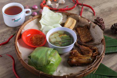 Tahta tabak, kızarmış et, sebze aperatifler, bir kase sos, ahşap masa arkaplanı.