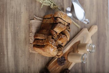 Süslü mutfak masasında kremalı ve kakao bardaklı dilimlenmiş ev yapımı kek.