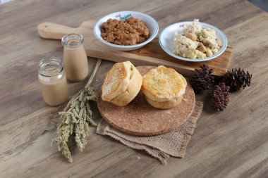 Ev yapımı çörekler ve kâselerle dekore edilmiş mutfak masasında aperatifler.