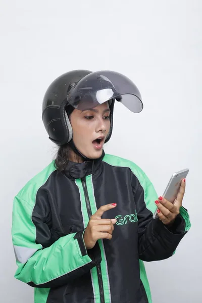 woman using helmet motorcycle holding smartphone. Young Asian woman wearing helmet before ride a motorcycle.