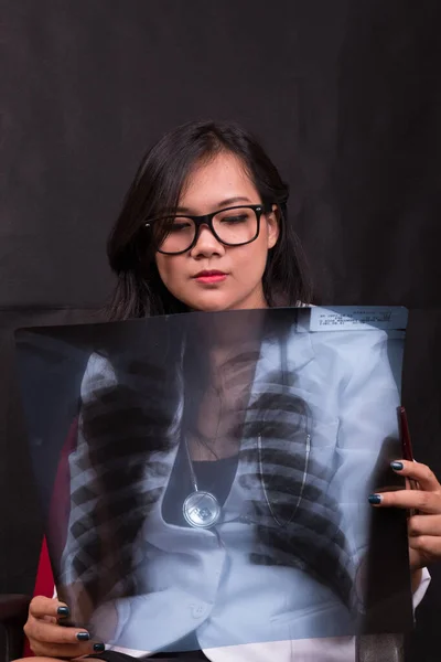 indonesia woman doctor holding stethoscope, report on white background