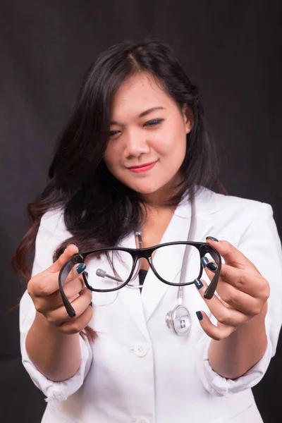 indonesia woman doctor holding stethoscope, report on white background