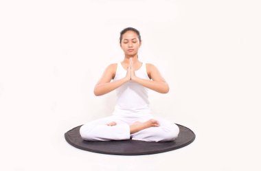 Namaste Mudra hareketleriyle lotus pozisyonunda oturan bir kadın. Kadın jimnastik salonunda meditasyon yapıyor.