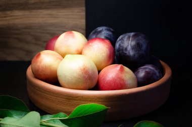 Erik ve nektarin karanlık ve ahşap arka plan üzerinde kil plaka üzerinde