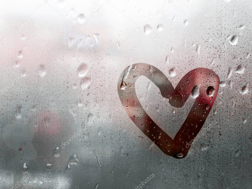 Heart painted on glass in Rainy weather, is fogged up and there are many drops on it