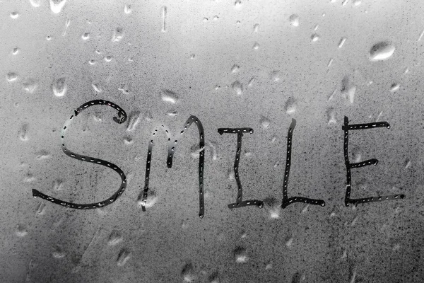 湿玻璃窗上的手工文字微笑 — 图库照片