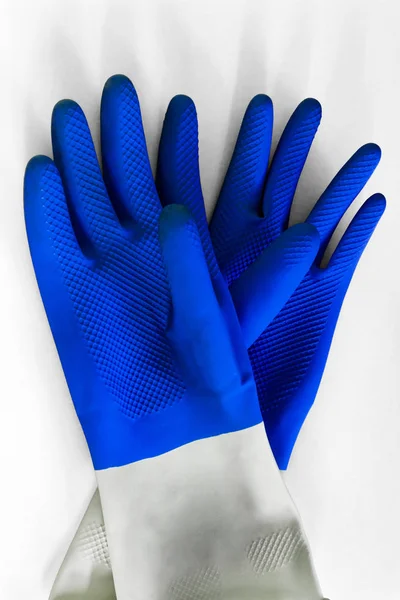 Blå gummi skydds handskar på den vita bakgrunden för olika ytor i rummet, badrum, kök. Tidig vår eller regelbunden sanering. Koncept för kommersiella städ företag. — Stockfoto