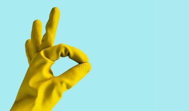 Sarı lastik eldiven elinde ok işareti, yalıtılmış nesne tasarımı ile kopya alanı için mavi arka plan üzerinde gösterir