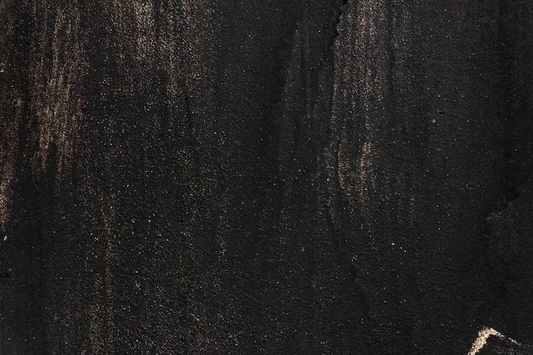 Black painted metal texture with smudges, scratches and gold sparkles — Stock Photo, Image