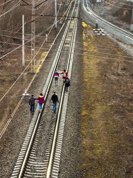 Ufa, Rosja-7 kwietnia 2019: Grupa nastolatków lub dzieci szkolnych udać się na tory kolejowe, promienie słońca ustawienie — Zdjęcie stockowe
