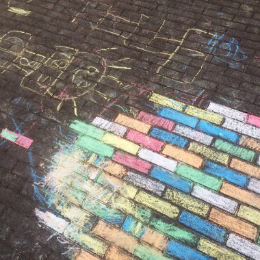 Pastel renklere sahip çocuklar tarafından oluşturulan kaldırım levhaları ve boya kalemi çizimrenkli tebeşir