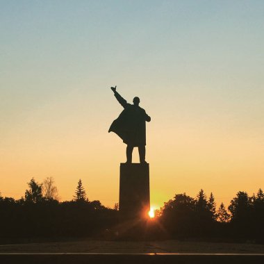 Ufa, Rusya - 1 Haziran 2016: Vladimir İlyiç Lenin'in şehir meydanında gökyüzüne ve gün batımı kirişlerine karşı heykeli. Broşürler, kartlar yazdırmak için konsept