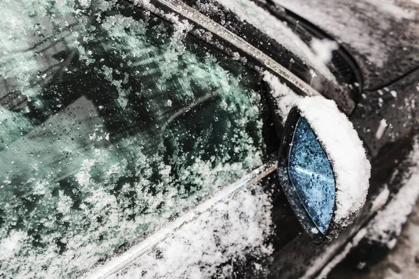 Espelho lateral do carro e janela do carro coberto com gelo e neve, limpeza de janelas, mau tempo, neve e gelo no vidro, líquido contra a formação de gelo, segurança rodoviária, tempestade de gelo — Fotografia de Stock