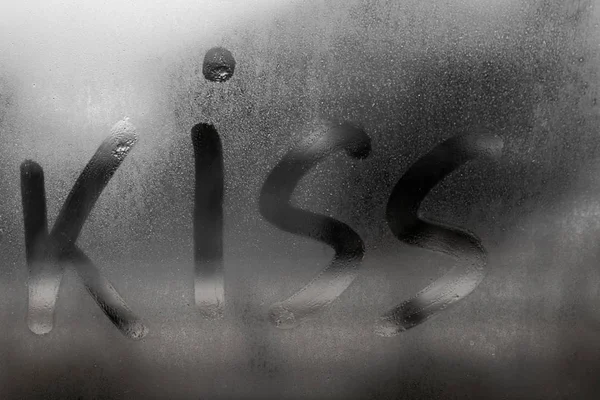 雨の秋の日に汗をかいたガラスに描かれたキスの碑文、寒い秋の天候、バレンタインデーのコンセプトで窓に凝縮と蒸気 — ストック写真
