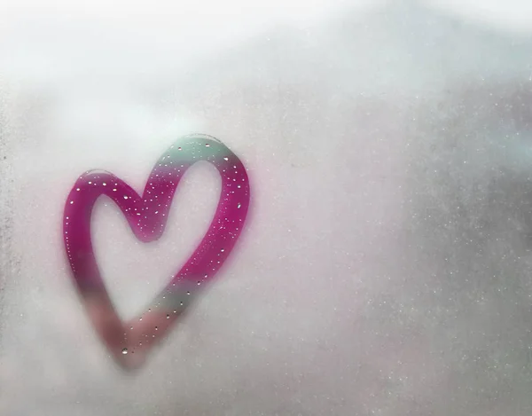 Purple heart outline painted on sweaty glass, many drops on it, inscription heart and love handmade on wet autumn foggy glass