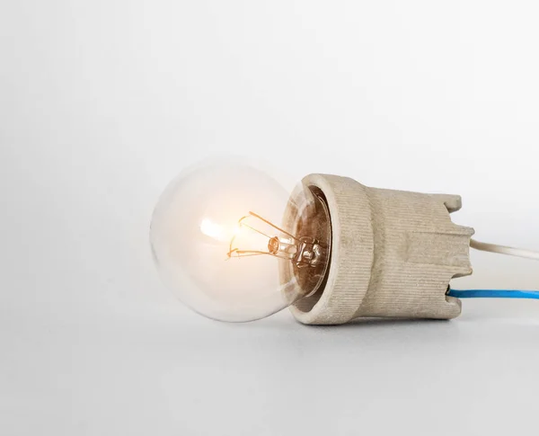 Belysning glödlampa glödlampa med lock, Socket, trådar ligger på vit bakgrund, ny idé koncept — Stockfoto