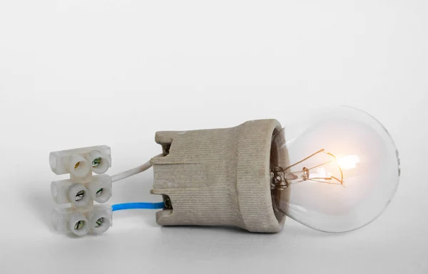 Belysning glödlampa glödlampa med mössa, uttag, ledningar och kopplingsplint ligger på vit bakgrund, ny idé koncept — Stockfoto