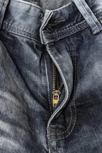 close-up zipper open on blue shabby jeans, denim texture, zipper jeans pants