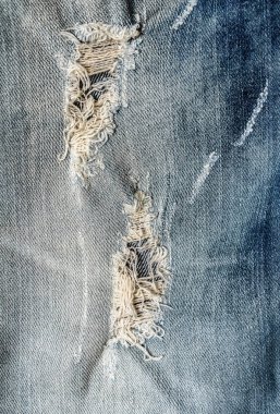 Denim Jeans 'in Deliği. Yırtılmış Yok Edilmiş Mavi Kot Pantolon. Mavi kot kumaşını kapat